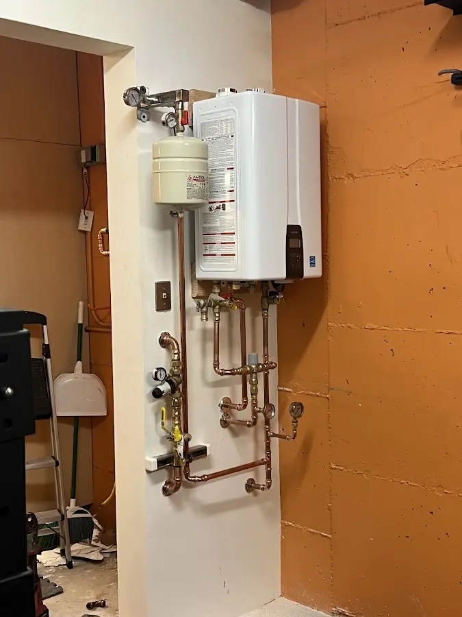 Plumbing technician inspecting water heater connections in Edgewater
